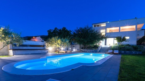 A modern house with a swimming pool, outdoor seating, and a well-lit patio area. - Serene Rural Villa with Pool, Sun Deck, and Children's Play Area - Five Bedroom Villa (Tugare)