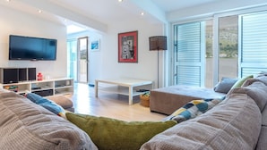 A modern living room with a flat-screen TV, a white coffee table, and a sofa set. - Serene Rural Villa with Pool, Sun Deck, and Children's Play Area - Five Bedroom Villa (Tugare)