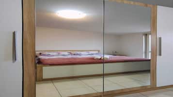 Une chambre à coucher avec un lit, une armoire et un miroir.