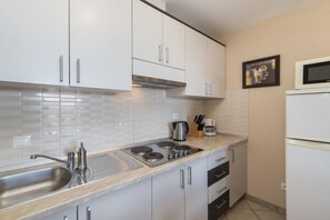 Kühlschrank, Mikrowelle, Herdplatte, Esstisch