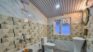 A bathroom with a toilet, bidet, and sink, tiled with patterned tiles and marble flooring. - The Kufri House (Theog)