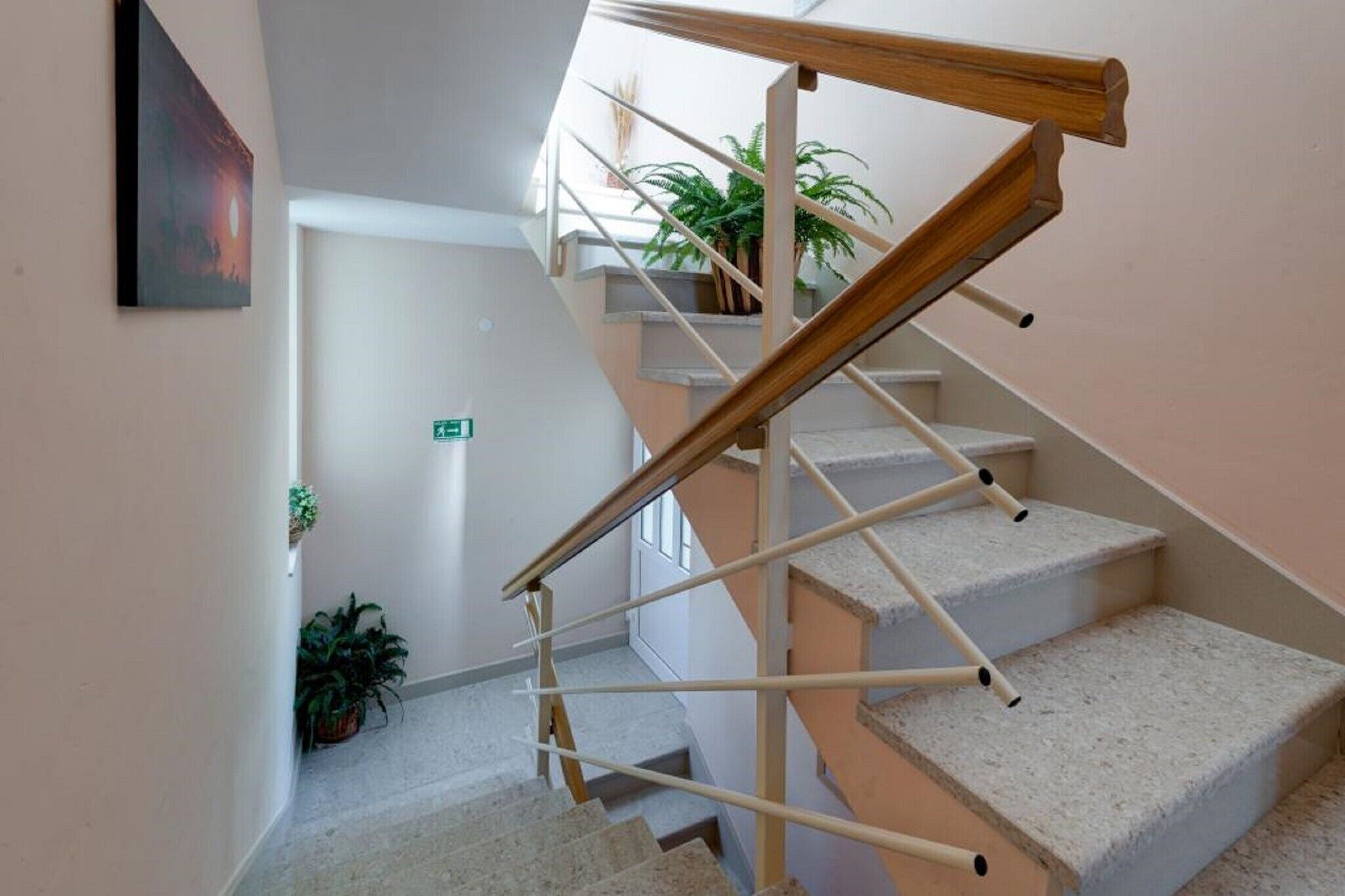 A staircase with a wooden handrail and beige steps.