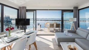 Une chambre moderne comprenant un coin repas, un canapé et un téléviseur.