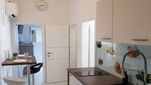 Una cocina moderna con comedor, un lavamanos y un reloj en la pared.
