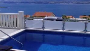 Una piscina con vista al mar y casas al fondo.
