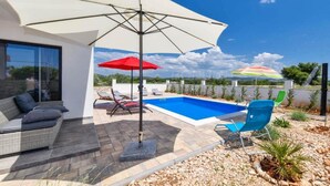 A modern outdoor pool area with a white umbrella, red and multicolored umbrellas, and lounge chairs. - Villa Sunrise with Outdoor Pool - 4 Bedroom & Pool (Šibenik)