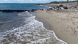 En strand med en stenig kust och lugna vågor.