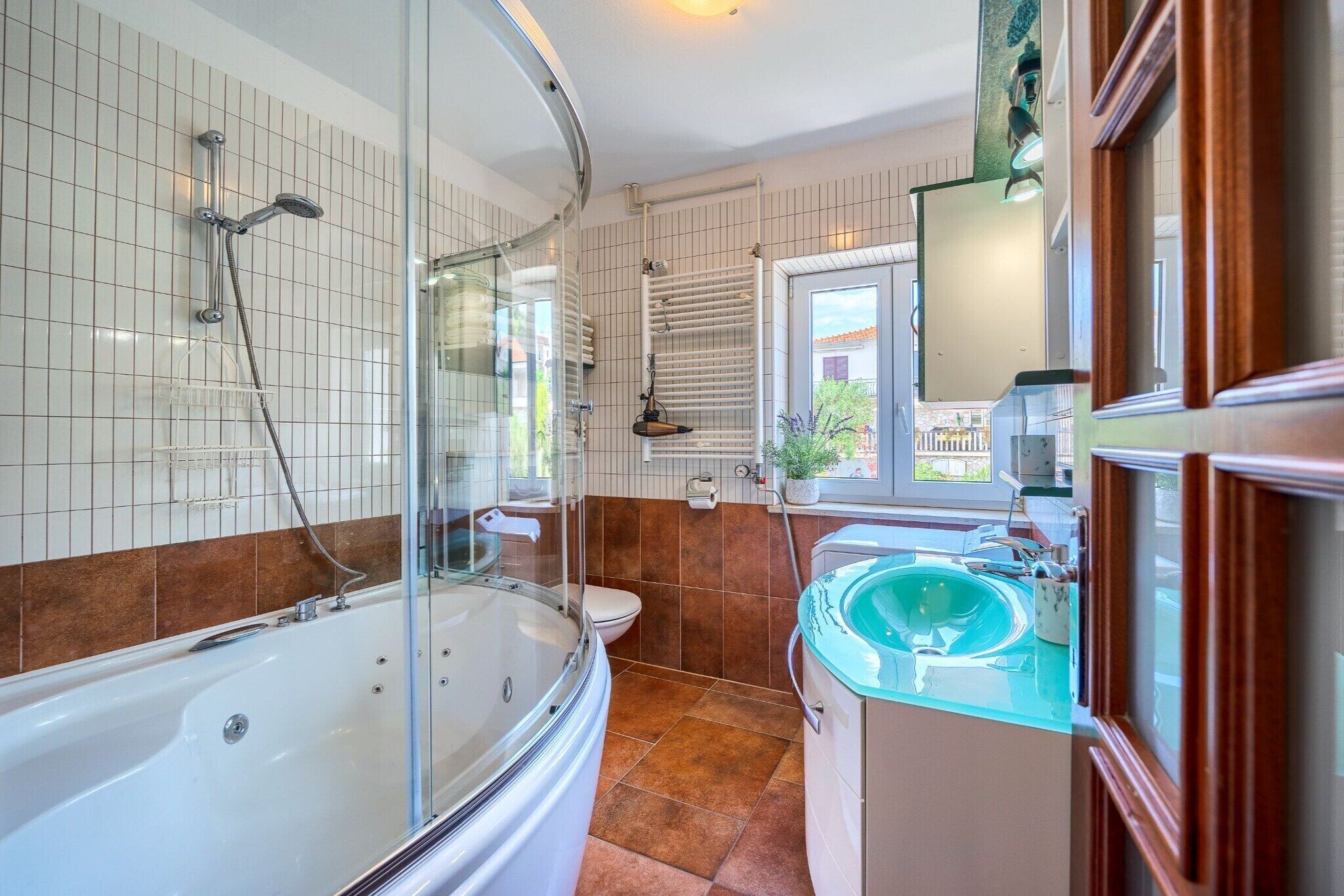 A bathroom with a bathtub, a glass-enclosed shower, a toilet, and a sink with a mirror.