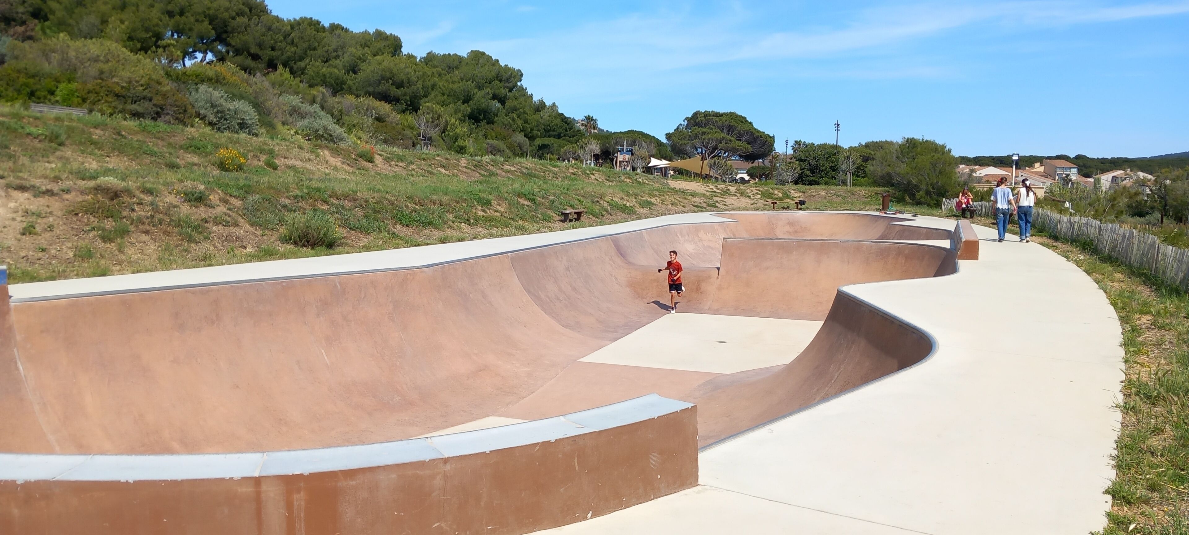 Et skatepark med en buet rampe og et fladt område.