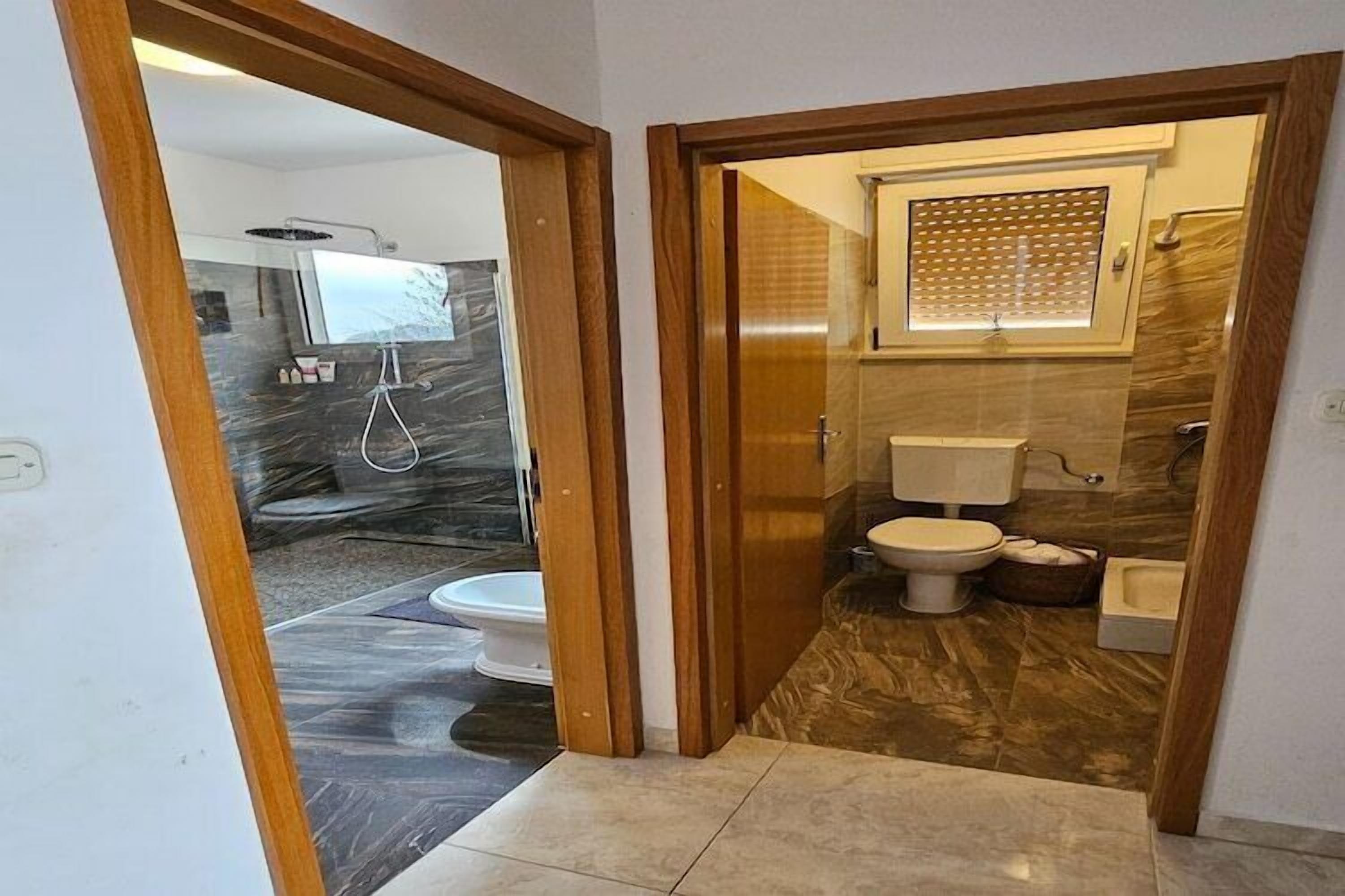 A modern bathroom with a shower, toilet, and bathtub.
