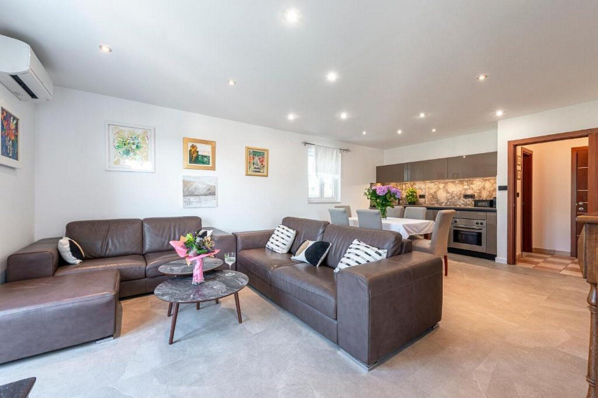 A modern living room with a sectional sofa, a coffee table, and artwork on the walls.