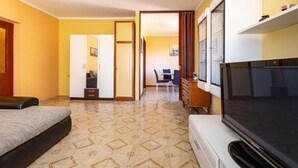 A hotel room with a bed, a TV, a desk, and a chair.