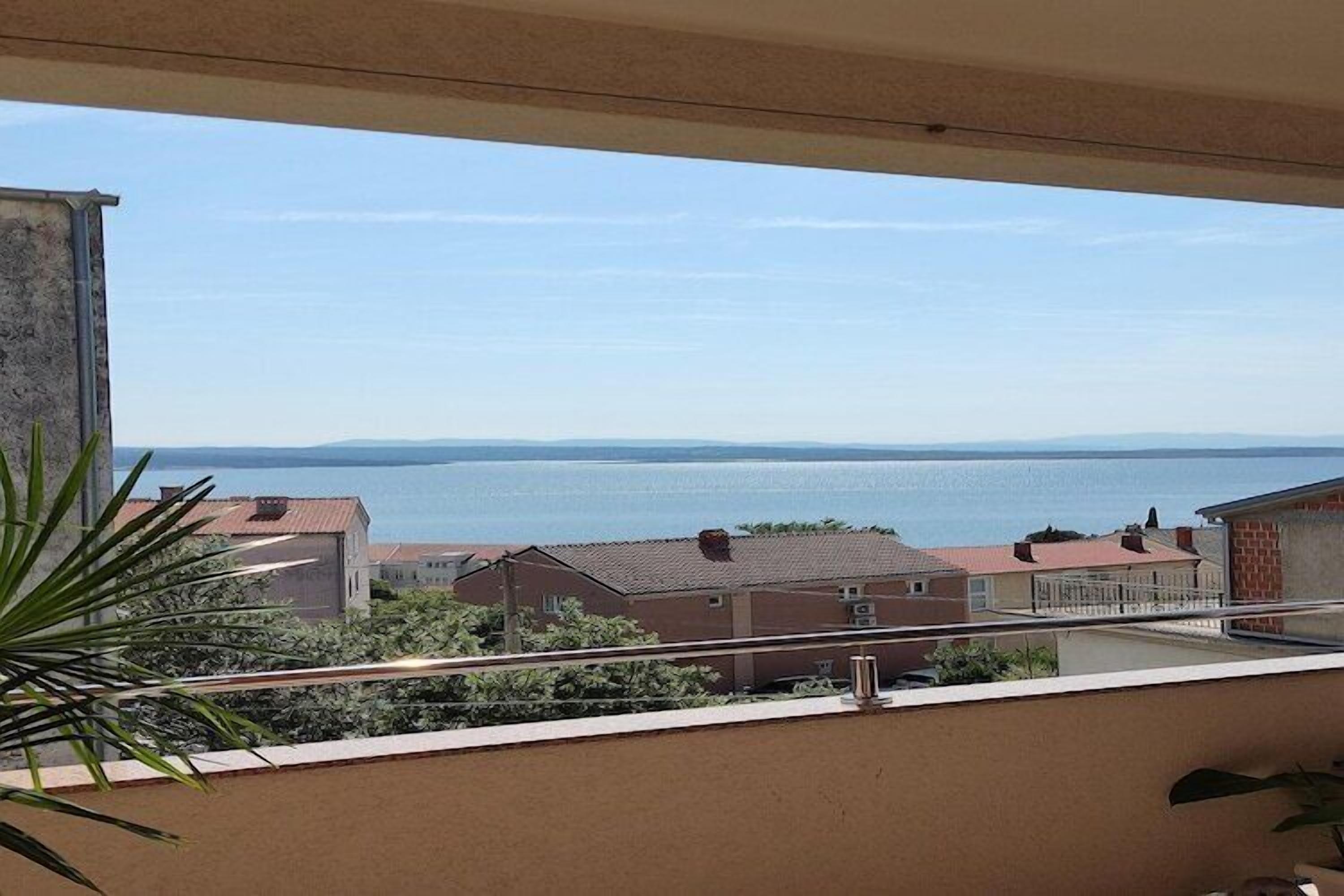 A balcony with a view of a body of water and buildings in the distance.