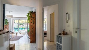 A modern interior with a kitchen, dining area, and a view through a glass door to an outdoor space. - Large 2 room apartment and beautiful terrace (Niza)