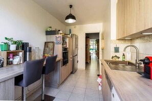 Uma cozinha moderna com armários de madeira, uma ilha central e forno embutido.