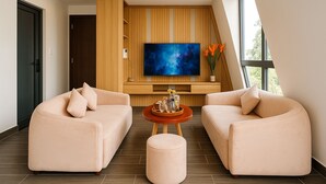 Uma sala de estar moderna com uma grande TV de tela plana, dois sofás, uma mesa de centro e uma parede de destaque em madeira.