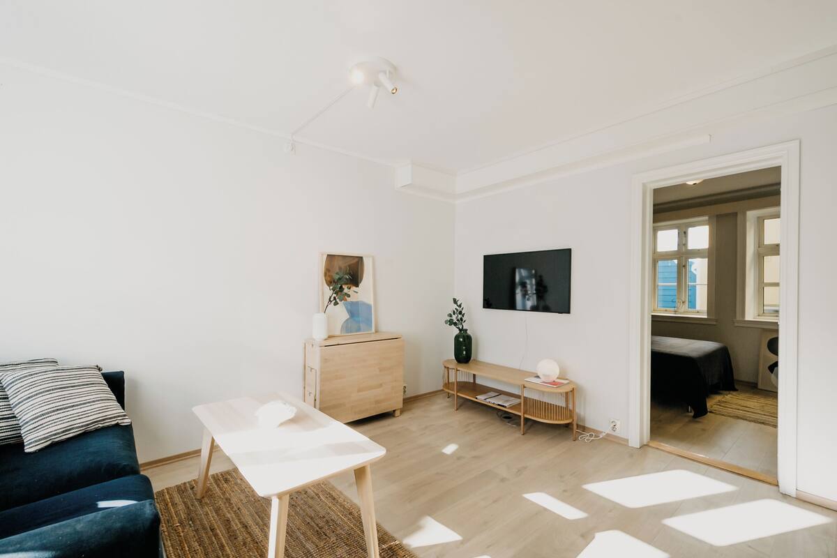 A modern living room with a sofa, a coffee table, a TV, and a wooden cabinet.