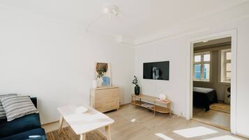 A modern living room with a sofa, a coffee table, a TV, and a wooden cabinet.