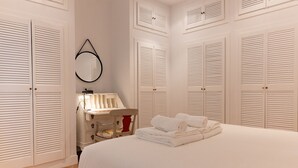 Un dormitorio con una cama grande, un tocador con espejo y varios armarios.