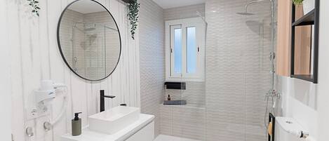 A modern bathroom with a white vanity, a round mirror, a toilet, and a shower area.