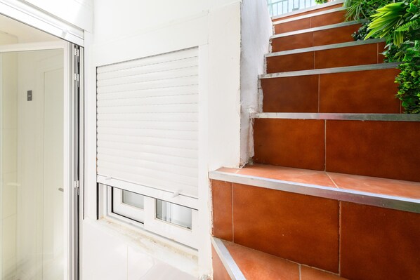 Eine Treppe mit Terrakottafliesen und einer weißen Tür mit Fenster.