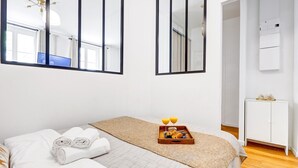 Ein Hotelzimmer mit Bett, einem Frühstücksbrett und einem großen Spiegel.