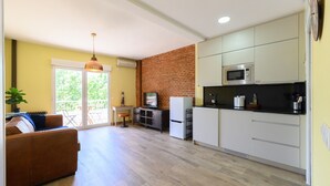 A compact living space with a kitchen, dining area, and a sofa. - Studio with balcony - Everything you need for a perfect stay in Madrid (Madrid)
