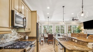 A spacious kitchen with granite countertops, stainless steel appliances, and a large island. - Modern Beach House w Pool - Walk to Beach! (Hilton Head Island)