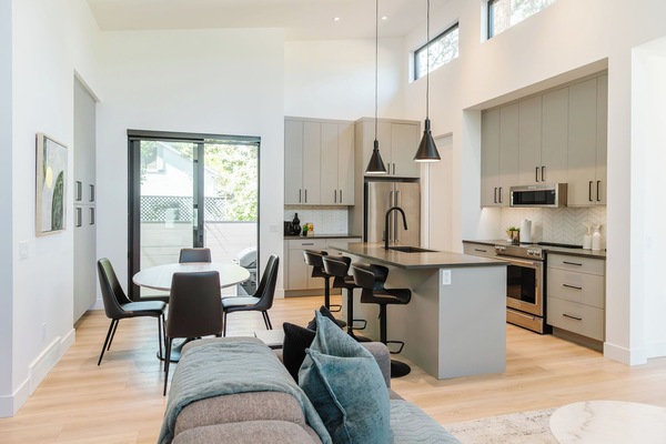 A modern, minimalist dining/kitchen area with ample natural light, offering a cozy setting ideal for shared meals and casual gatherings.