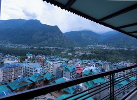 Uma cidade com edifícios de telhados verdes, rodeada por montanhas.