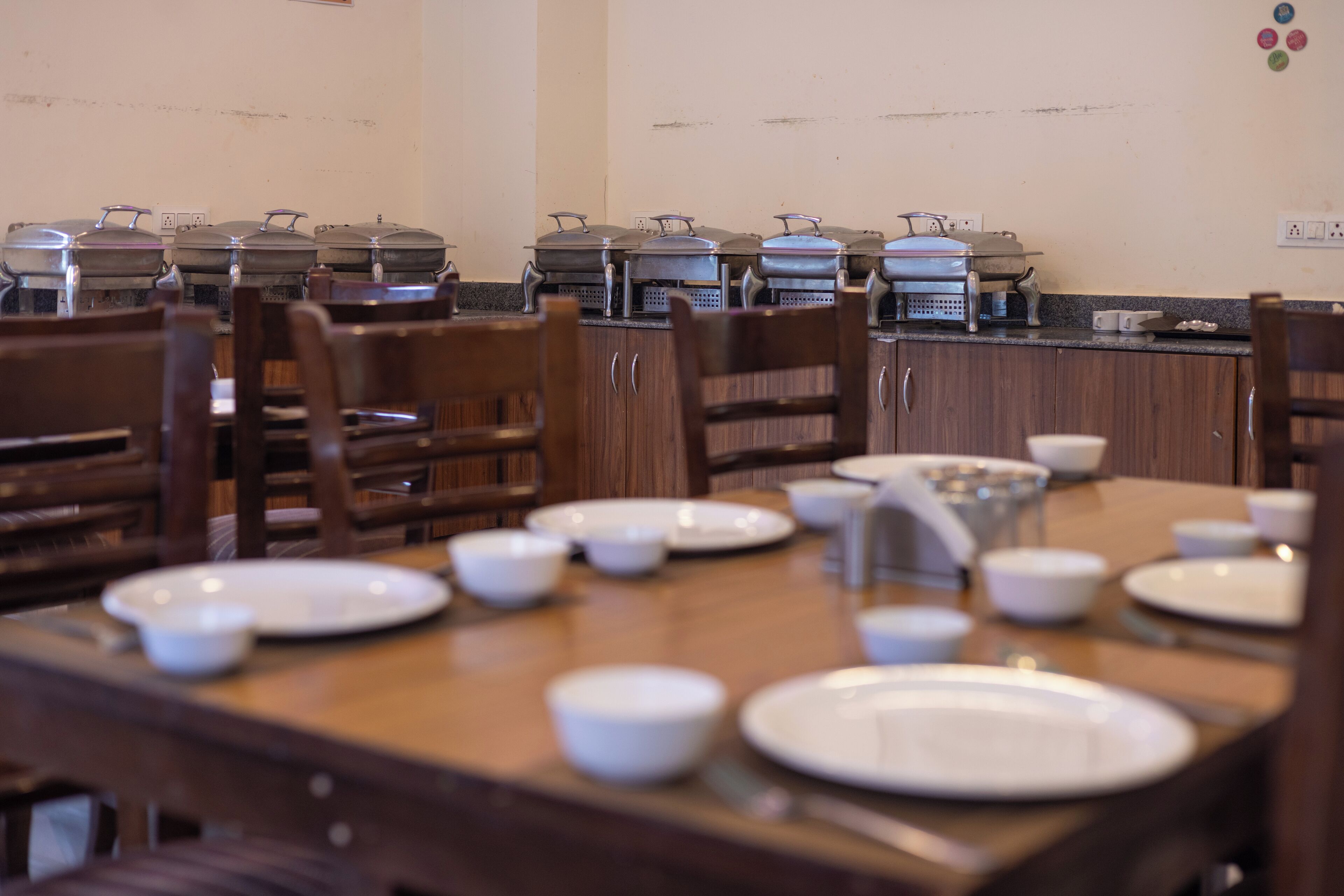 A dining area with multiple tables set for meals, each with bowls, plates, and cutlery.