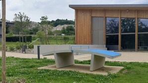 A modern building with a wooden facade and large windows. - 2-room apartment village center (Etaux)
