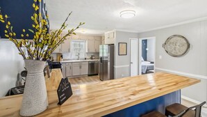 Una cocina moderna con encimeras de madera, estufa integrada y refrigerador.