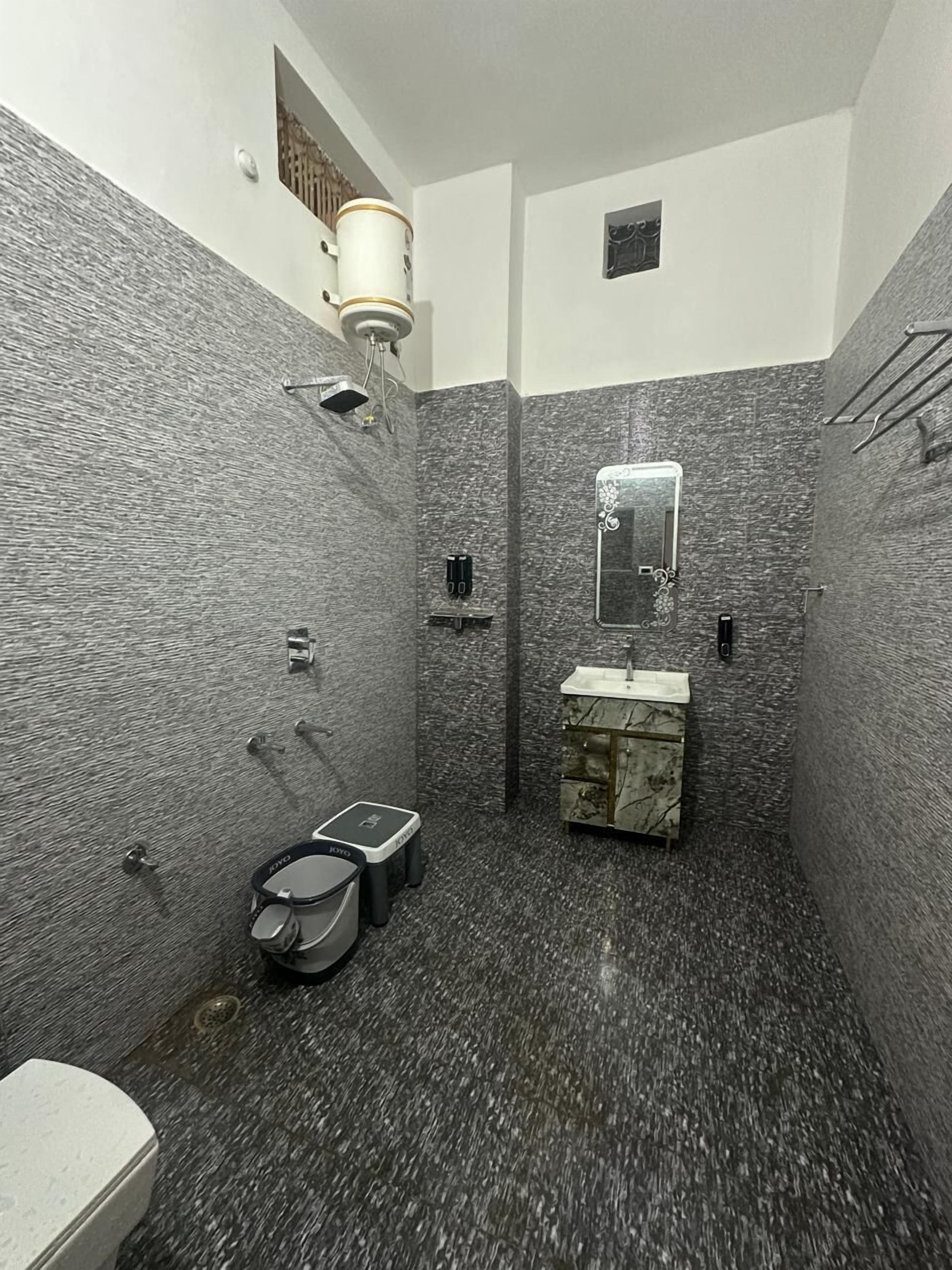 Une petite salle de bain avec un lavabo en marbre, des toilettes et une douche.