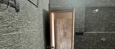 Un bagno con una porta in legno, un water e un porta asciugamani.