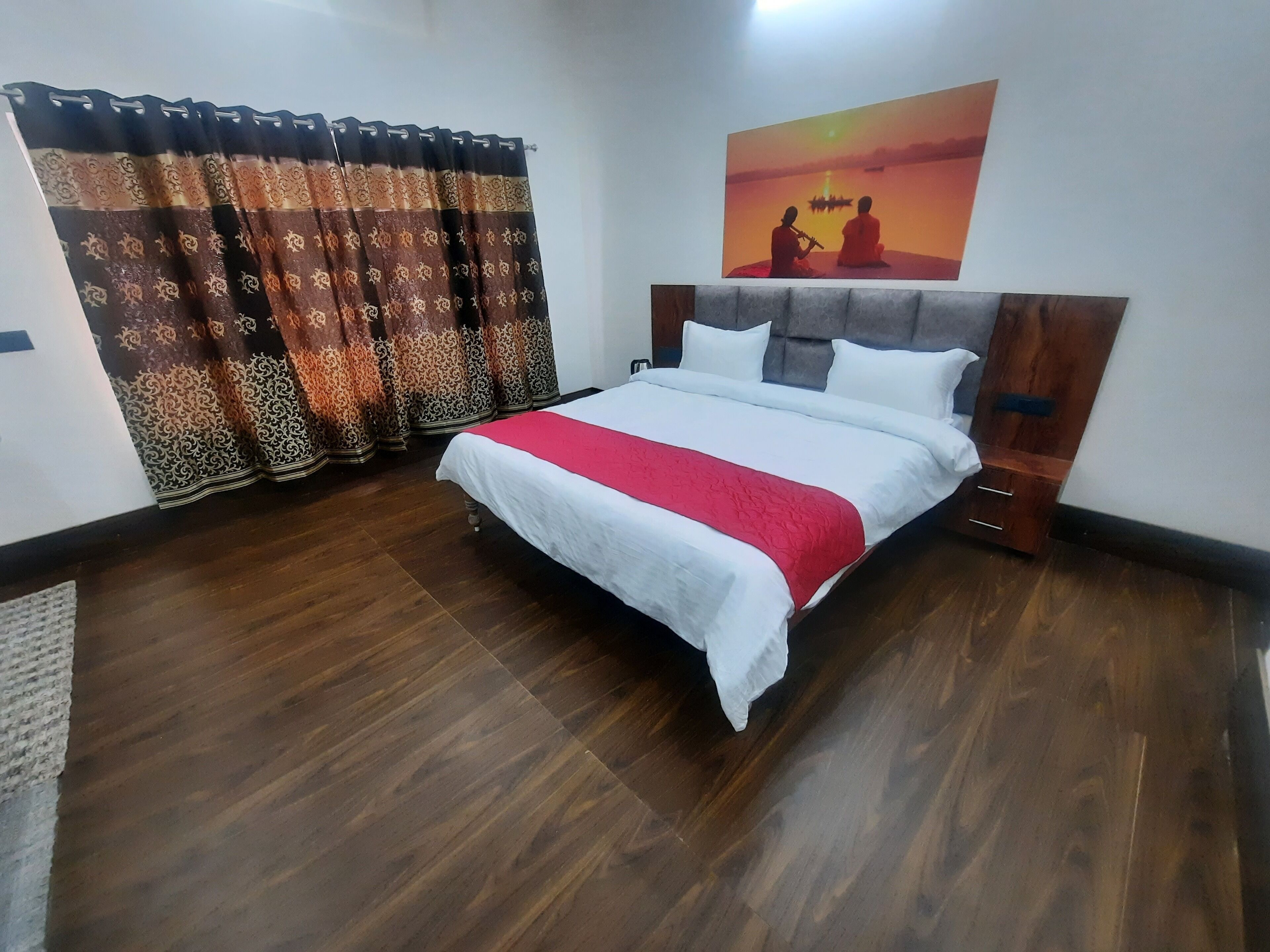 A neatly arranged bedroom with a bed, curtains, and a painting on the wall.