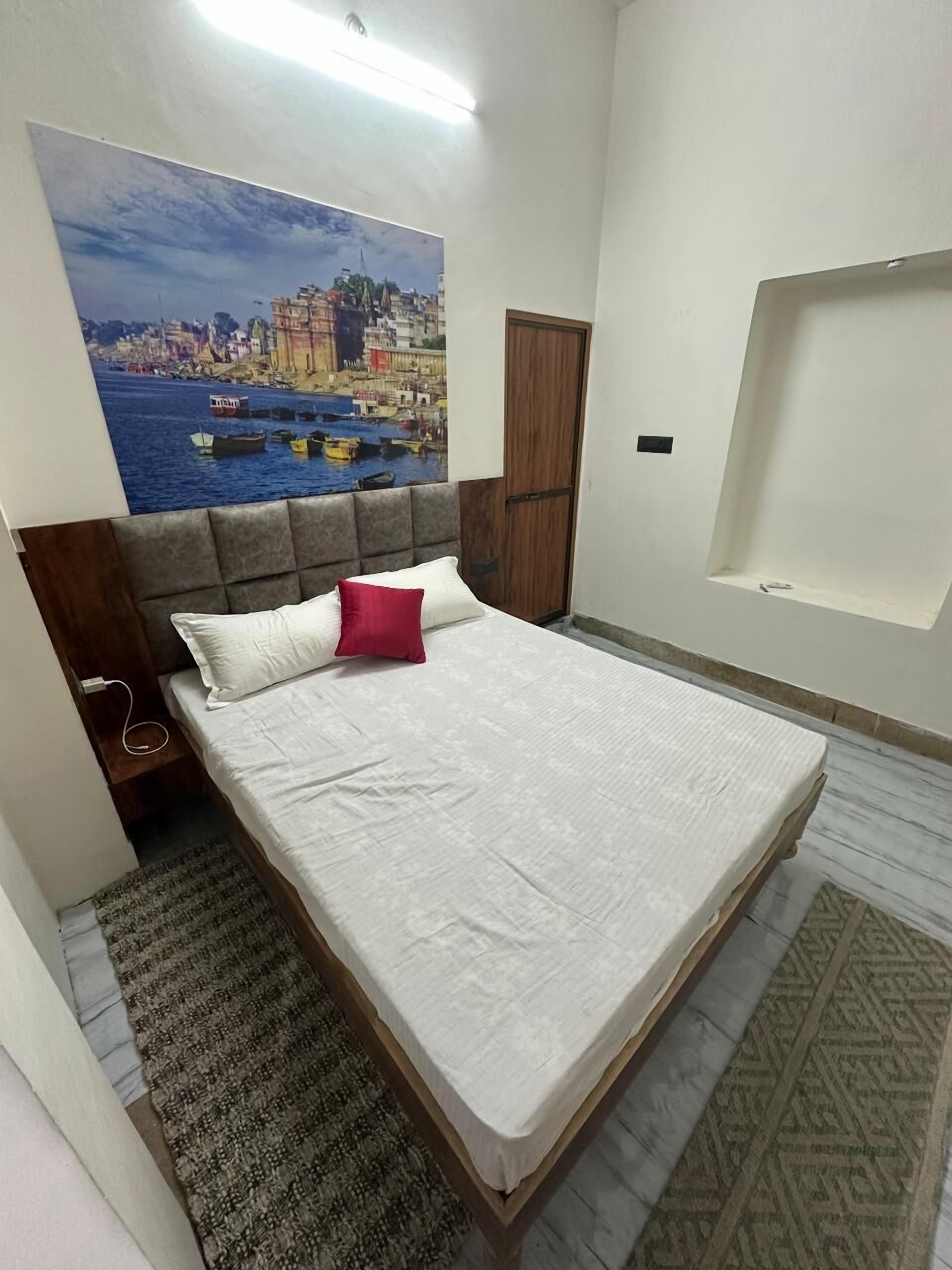 Un dormitorio con una cama grande, un cabecero, una mesita de noche, un armario de madera, un estante de pared y una alfombra estampada.