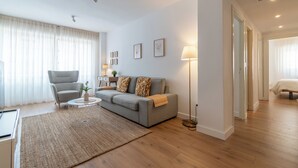 A modern living room with a grey sofa, a round coffee table, and a floor lamp.