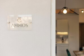 A sign with the name "AMMOS" on a white wall. - Palea Luxury Living (Chania)