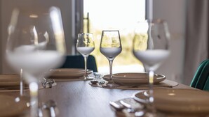 Une table à manger dressée avec des verres à vin, des assiettes et des couverts.