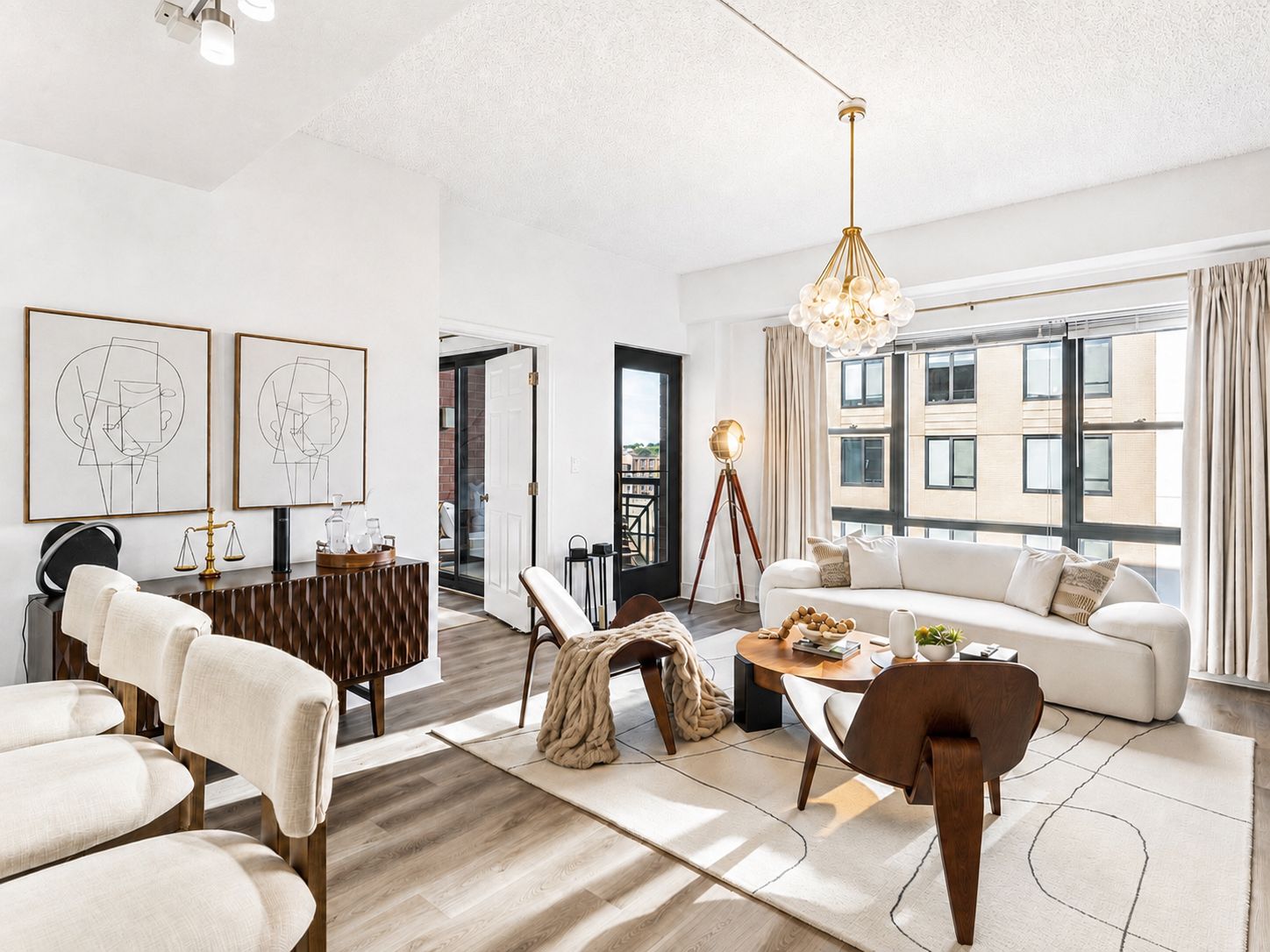 A modern living room with a sofa, chairs, a coffee table, and artwork on the walls.