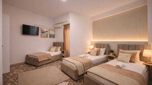 A hotel room with two beds, a TV, and a large window. - KURTI Hotel (Golem)