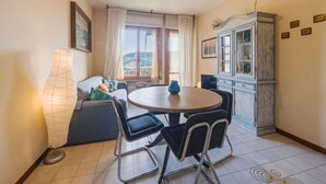 Un coin repas accueillant avec une table ronde, des chaises, une lampe, un canapé et un meuble.