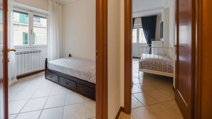 Une chambre à coucher avec un lit, un radiateur et une fenêtre avec des rideaux.