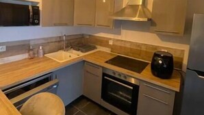 A compact kitchen with a microwave, stove, sink, and a coffee maker. - Tarascon center apartment (Tarascon)