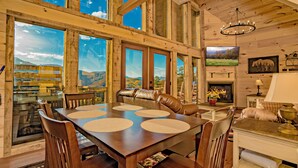 A wooden dining room with a large table, chairs, and a fireplace. - 🌲 Paradise View In The Smokies 🌅 Views, Resort Pool & Game Room (Sevierville)