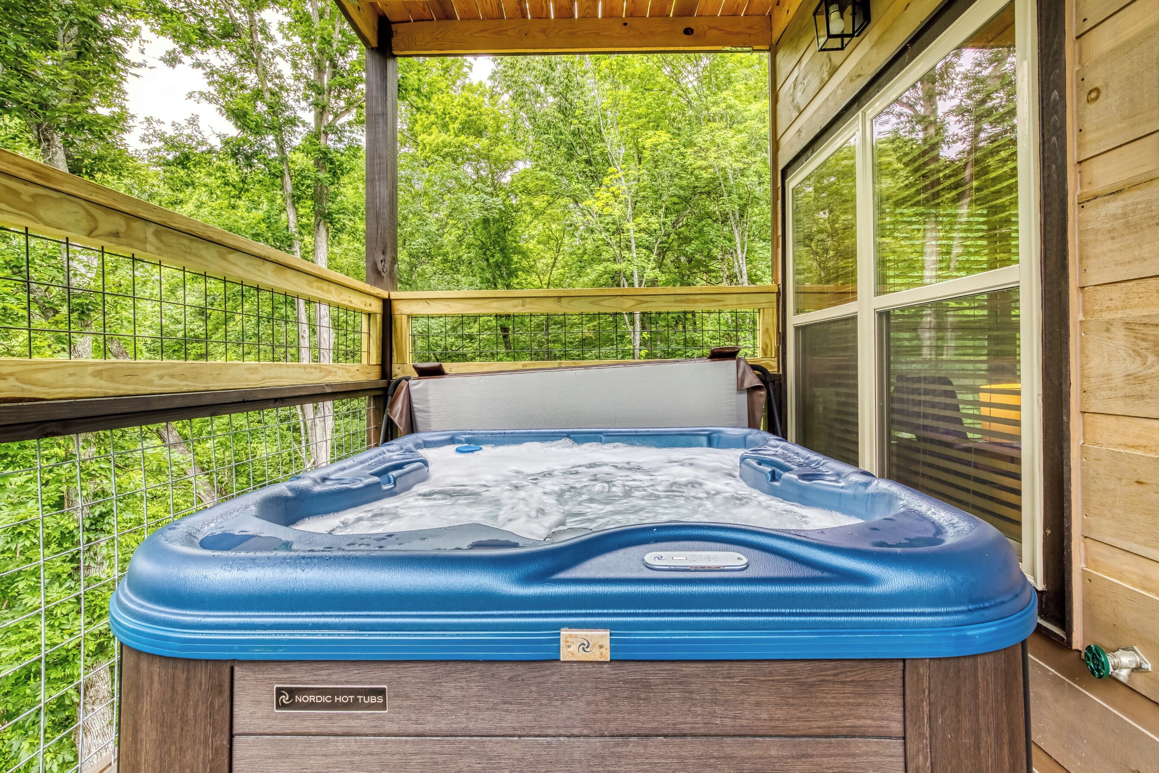 Un bain à remous sur une terrasse en bois, avec vue sur les arbres.