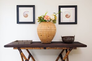 A wooden table with a woven basket and a vase with flowers. - Overthemoon Luxury Pool Villas (Koh Tao)