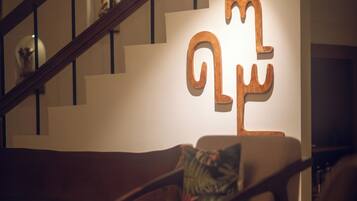 A staircase with a wooden handrail and a wall-mounted sculpture.