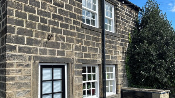 A two-story stone building with a black door and white-framed windows. - Charming pottery barn conversion 2 mins from Horsforth train station. (Horsforth)